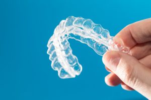 Image of person holding Invisalign. 