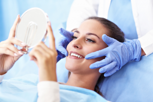 Image of a person looking at dental crown in the mirror. 